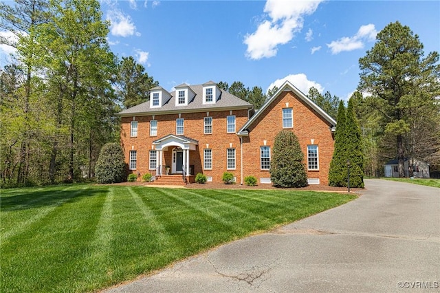 view of front of property featuring brick siding and a front lawn