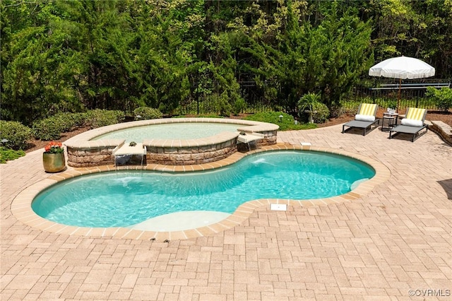 view of pool featuring a pool with connected hot tub, fence, and a patio
