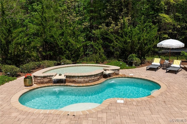 view of pool with a pool with connected hot tub, fence, and a patio