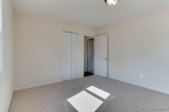unfurnished bedroom featuring a closet, baseboards, and carpet floors