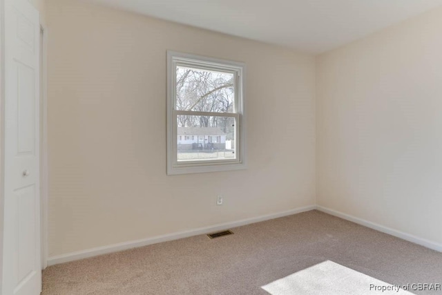 empty room with visible vents, baseboards, and carpet