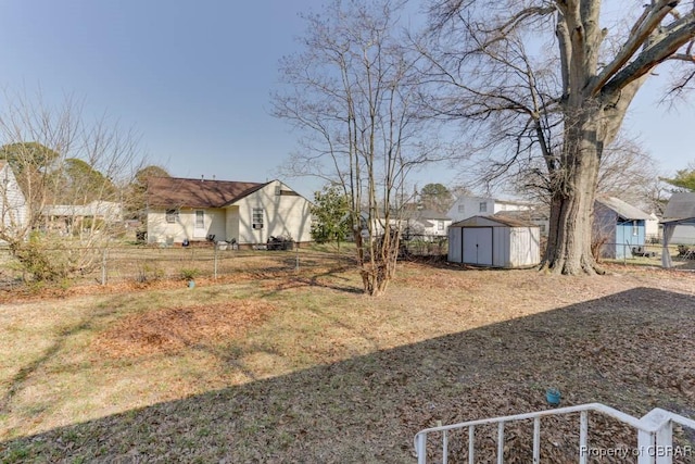 view of yard featuring an outbuilding, a storage unit, and fence private yard