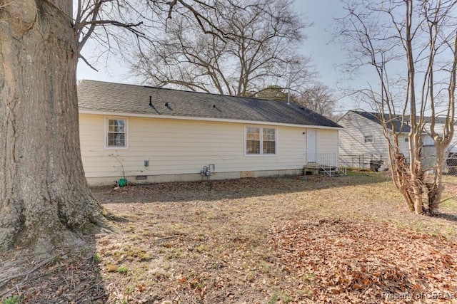 rear view of house with entry steps, roof with shingles, and crawl space