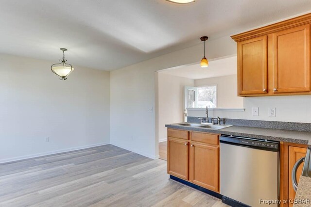kitchen featuring decorative light fixtures, a sink, light wood-style floors, and stainless steel dishwasher