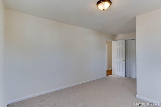 empty room with light carpet and baseboards