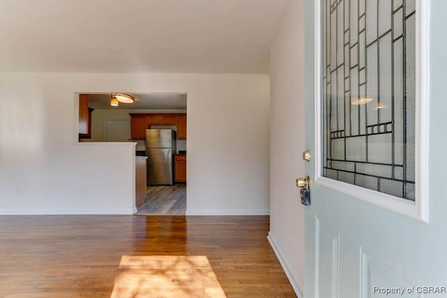 entryway with baseboards and wood finished floors