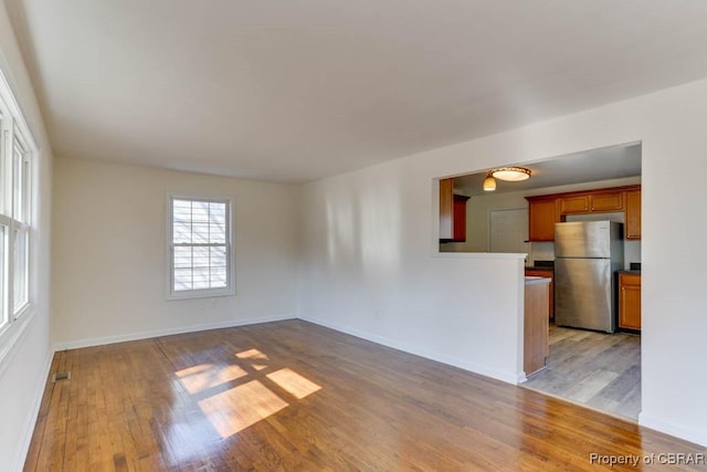 unfurnished living room with visible vents, baseboards, and light wood-style floors