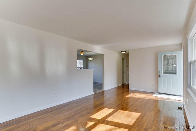 empty room with visible vents, baseboards, and wood finished floors