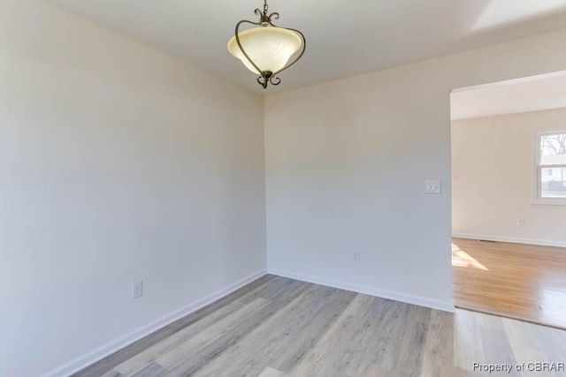 unfurnished room featuring baseboards and wood finished floors