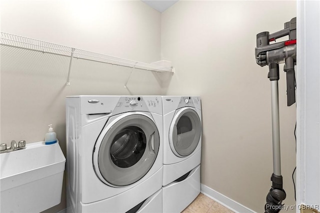 22 Crossroad, Irvington, VA 22480 - laundry room with baseboards, washer and clothes dryer, laundry area, light tile patterned flooring, and a sink