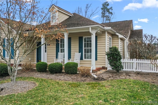 22 Crossroad, Irvington, VA 22480 - view of front facade with a front lawn, fence, covered porch, and a shingled roof