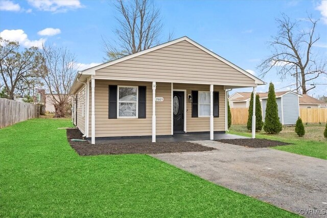 bungalow-style house with a front lawn and fence