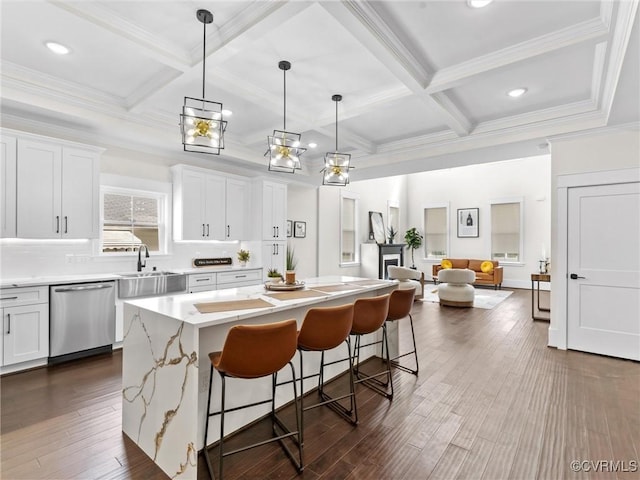 kitchen with stainless steel dishwasher, a breakfast bar, a center island, a sink, and coffered ceiling