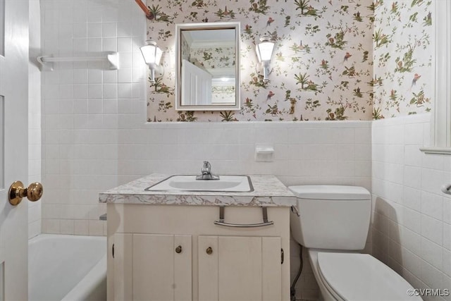 bathroom featuring wallpapered walls, tile walls, and toilet