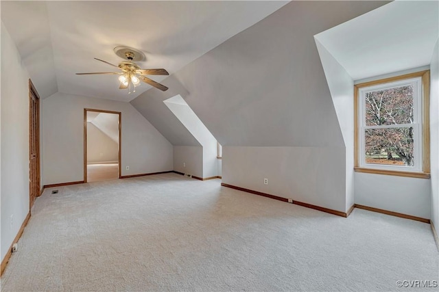 additional living space with vaulted ceiling, carpet flooring, a ceiling fan, and baseboards