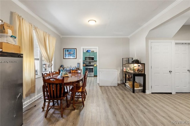 dining room with baseboards, ornamental molding, and light wood-style flooring