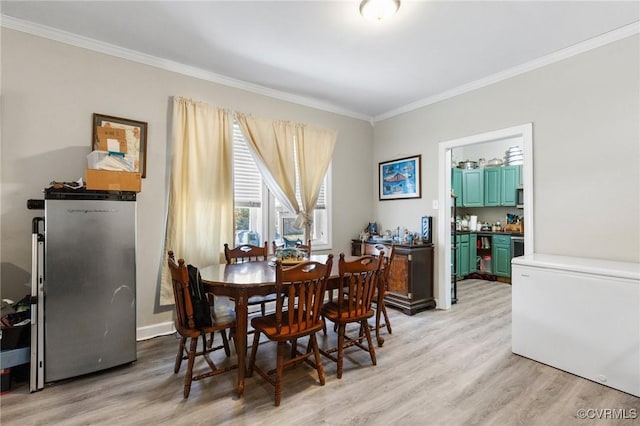 dining room featuring light wood-style flooring and crown molding