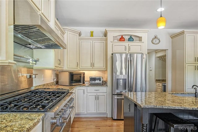 1729 Lake Forest Dr, Mineral, VA 23117 - kitchen featuring light stone counters, cream cabinetry, under cabinet range hood, and stainless steel appliances