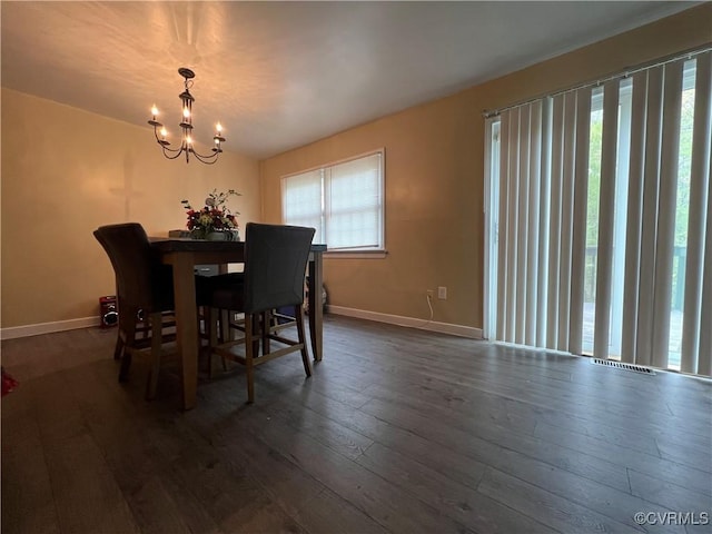 dining area featuring baseboards, dark wood-style flooring, and a notable chandelier