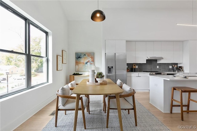 1613 Pulaski St, Richmond, VA 23222 - dining space with visible vents, light wood-style floors, and a towering ceiling