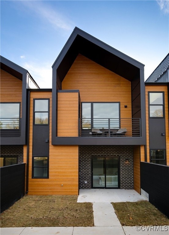 1613 Pulaski St, Richmond, VA 23222 - modern home with brick siding, a balcony, and fence