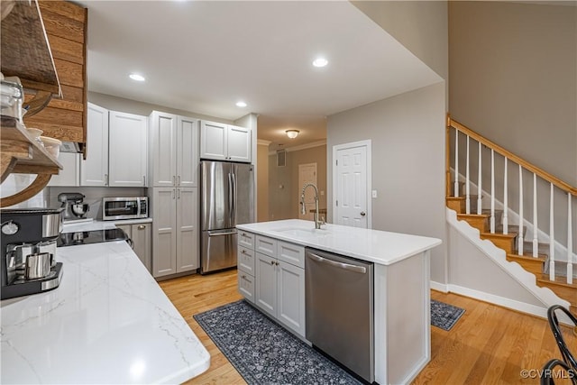 1635 Dorset Meadows Ln, Powhatan, VA 23139 - kitchen with stainless steel appliances, light wood finished floors, recessed lighting, light stone countertops, and a center island with sink