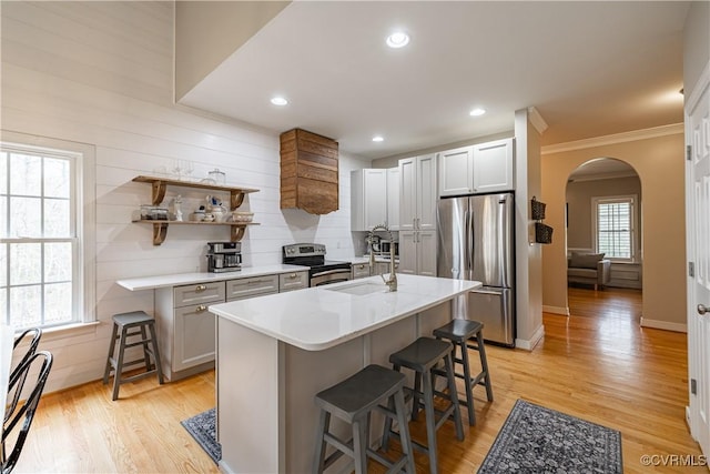 1635 Dorset Meadows Ln, Powhatan, VA 23139 - kitchen featuring stainless steel appliances, arched walkways, a breakfast bar, light countertops, and ornamental molding
