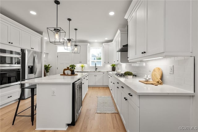 613 W Lancaster Rd, Richmond, VA 23222 - kitchen with decorative backsplash, white cabinets, appliances with stainless steel finishes, a sink, and a center island