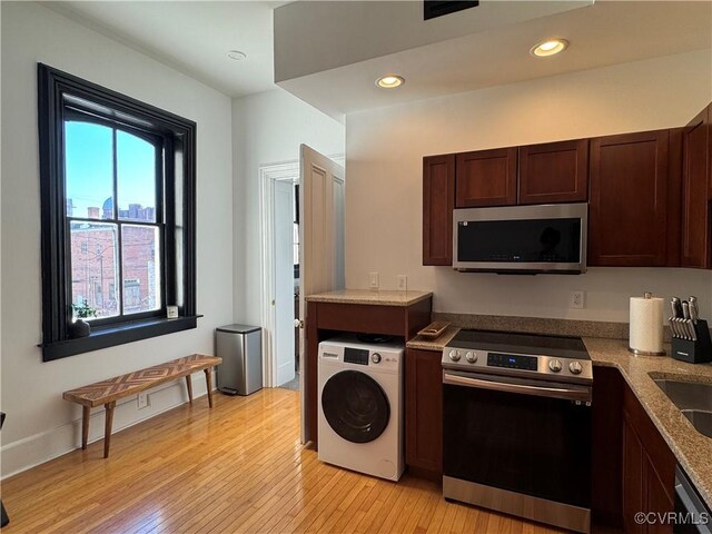 kitchen featuring dark brown cabinetry, recessed lighting, washer / dryer, appliances with stainless steel finishes, and light wood-style flooring
