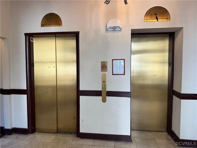 hallway featuring elevator and light tile patterned flooring