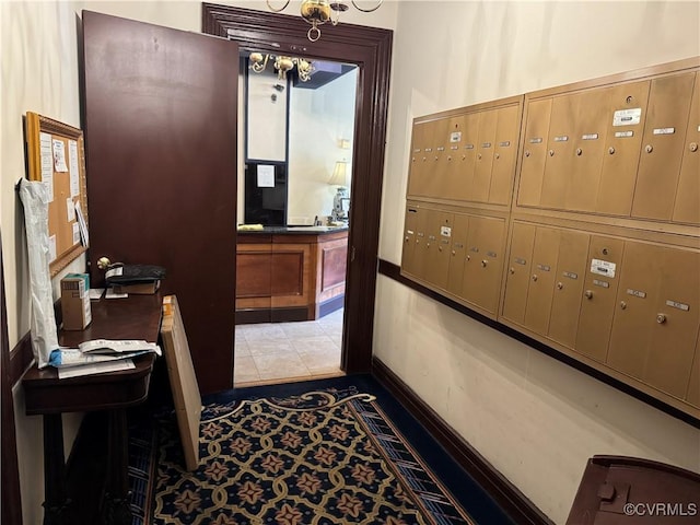 office featuring mail area, light tile patterned floors, and baseboards