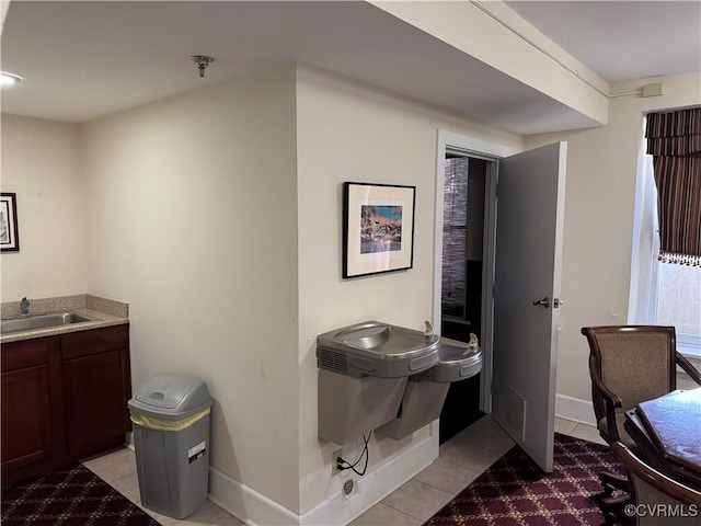 bathroom featuring tile patterned floors, baseboards, and a sink