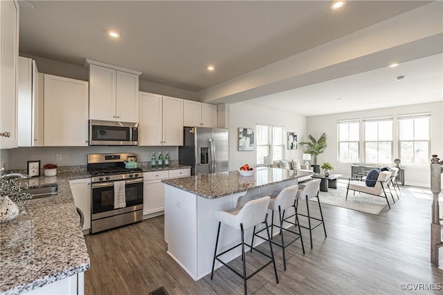 6328 Gossamer Aly, Moseley, VA 23120 - kitchen featuring a kitchen breakfast bar, a center island, appliances with stainless steel finishes, dark wood-style flooring, and a sink
