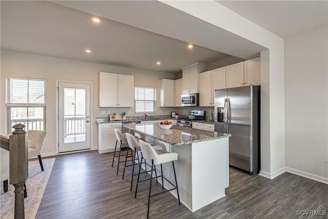6328 Gossamer Aly, Moseley, VA 23120 - kitchen with dark wood-style flooring, a center island, a kitchen breakfast bar, and stainless steel appliances