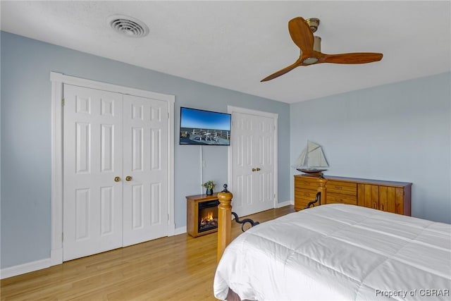289 Oyster Shell Rd, Laneview, VA 22560 - bedroom featuring multiple closets, wood finished floors, baseboards, and a ceiling fan