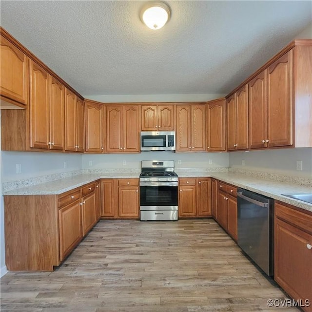 6118 Pond Grass Rd, Mechanicsville, VA 23111 - kitchen with brown cabinets, light countertops, light wood-style floors, and appliances with stainless steel finishes
