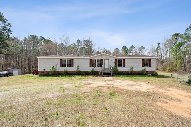 manufactured / mobile home with entry steps, an outdoor structure, a front yard, and crawl space
