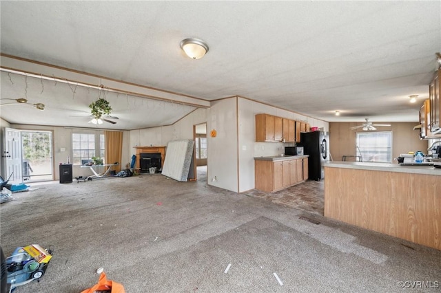 kitchen featuring open floor plan, black fridge with ice dispenser, light colored carpet, and ceiling fan