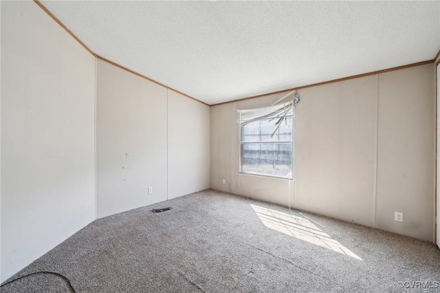 carpeted spare room with a textured ceiling and crown molding