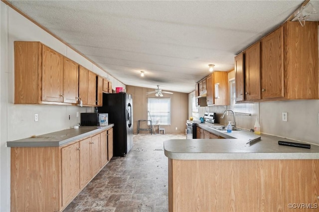 kitchen with a sink, range with electric stovetop, a peninsula, ceiling fan, and vaulted ceiling