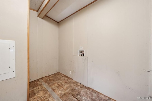 washroom featuring electric panel, laundry area, hookup for a washing machine, and stone finish flooring