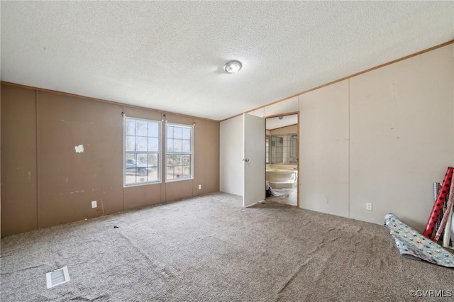 unfurnished bedroom featuring carpet flooring, visible vents, and a textured ceiling