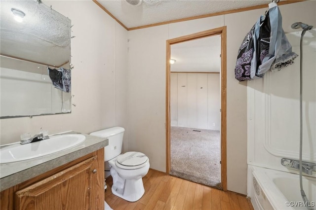 bathroom with vanity, shower / bathtub combination with curtain, wood finished floors, a textured ceiling, and toilet