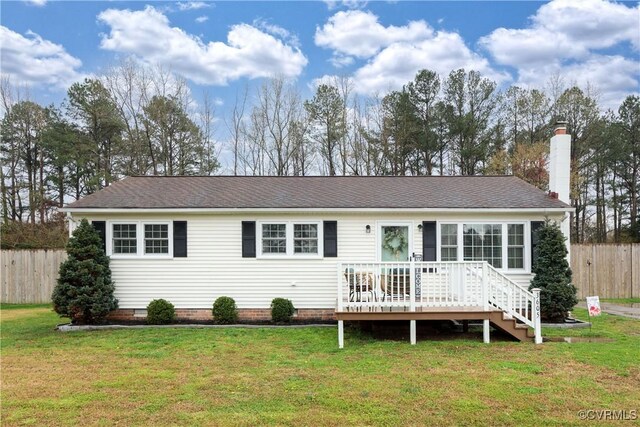 view of front facade featuring a chimney, a front yard, a wooden deck, and fence