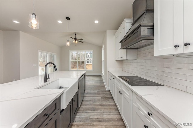 LOT73 Dove Ct, Louisa, VA 23024 - kitchen featuring premium range hood, decorative light fixtures, a sink, black electric cooktop, and lofted ceiling