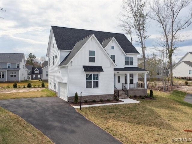 view of front of house featuring an attached garage, board and batten siding, aphalt driveway, a front yard, and a porch