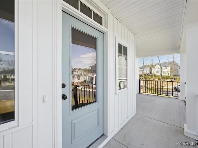 doorway to property with board and batten siding and a porch