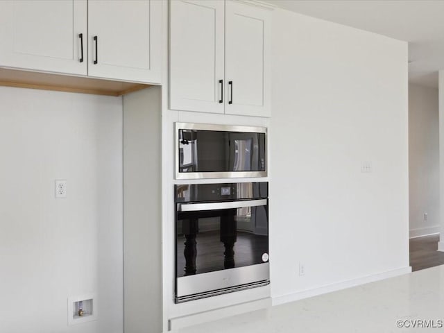 kitchen with white cabinetry, appliances with stainless steel finishes, and baseboards