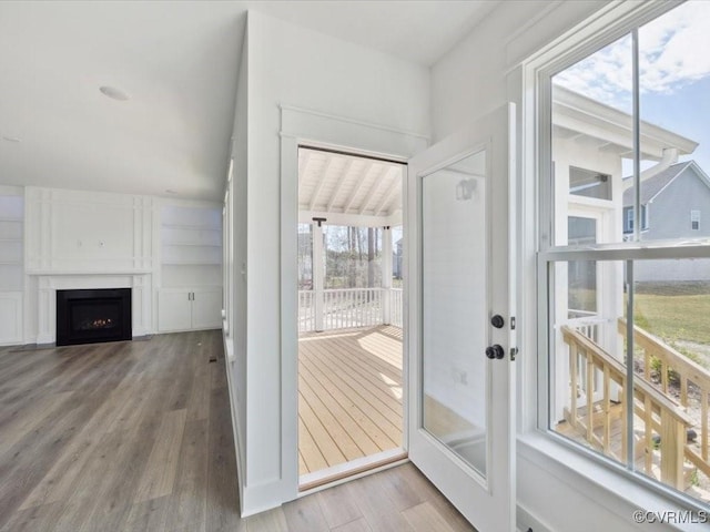 doorway with a fireplace and wood finished floors