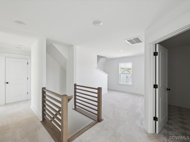 corridor featuring carpet floors, an upstairs landing, and visible vents